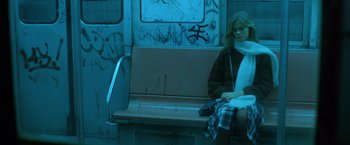 Movie still from “The New York Ripper” (1982), directed by Lucio Fulci – A woman sitting on a bench on a train; Medium shot, Low angle