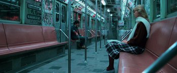 Movie still from “The New York Ripper” (1982), directed by Lucio Fulci – A man sitting on a subway train next to a woman; Wide shot, High angle
