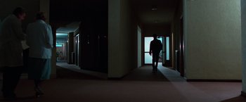 Movie still from “The New York Ripper” (1982), directed by Lucio Fulci – A man walking down a hallway in a building; Extreme Wide shot, Low angle