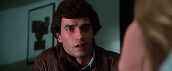 Movie still from “The New York Ripper” (1982), directed by Lucio Fulci – A person wearing a leather jacket; Close Up shot, Over the shoulder angle