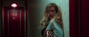 Movie still from “The New York Ripper” (1982), directed by Lucio Fulci – A woman with long blonde curly hair wearing a jacket; Close Up shot, Low angle