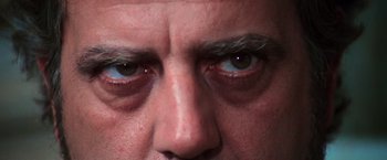 Movie still from “The New York Ripper” (1982), directed by Lucio Fulci – A man's eyes with blue eyes; Extreme Close Up shot, Low angle
