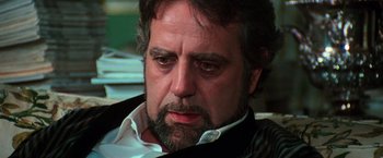 Movie still from “The New York Ripper” (1982), directed by Lucio Fulci – A person wearing a suit and tie; Close Up shot, Low angle