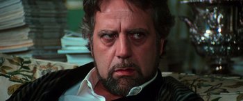 Movie still from “The New York Ripper” (1982), directed by Lucio Fulci – A person with a beard and mustache; Close Up shot, Low angle