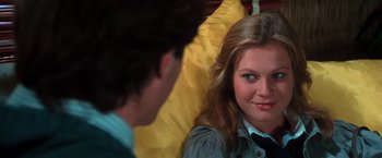 Movie still from “The New York Ripper” (1982), directed by Lucio Fulci – A woman sitting next to a man on a yellow couch; Close Up shot, Over the shoulder angle