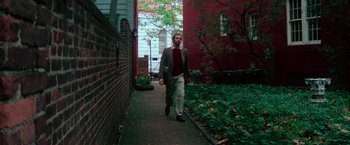 Movie still from “The New York Ripper” (1982), directed by Lucio Fulci – A man walking down a brick walkway in a suit; Wide shot, Low angle