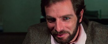 Movie still from “The New York Ripper” (1982), directed by Lucio Fulci – A person wearing a suit and tie; Close Up shot, Low angle