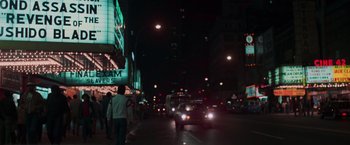 Movie still from “The New York Ripper” (1982), directed by Lucio Fulci – A city street at night lit up by streetlights; Extreme Wide shot, Low angle