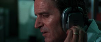 Movie still from “The New York Ripper” (1982), directed by Lucio Fulci – A person wearing a pair of headphones; Close Up shot, Low angle