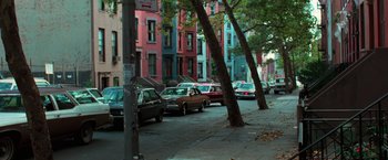 Movie still from “The New York Ripper” (1982), directed by Lucio Fulci – Cars parked on the side of the road near a tree; Extreme Wide shot, High angle