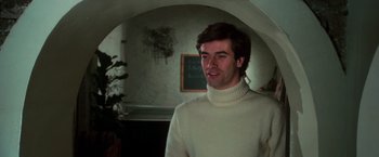 Movie still from “The New York Ripper” (1982), directed by Lucio Fulci – A man wearing a white sweater standing in a room; Close Up shot, Low angle