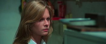 Movie still from “The New York Ripper” (1982), directed by Lucio Fulci – A woman with long blonde hair is looking to her left; Close Up shot, Over the shoulder angle