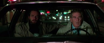 Movie still from “The New York Ripper” (1982), directed by Lucio Fulci – Two men sitting in the back of a car at night; Close Up shot, Low angle