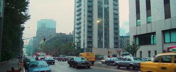 Movie still from “The New York Ripper” (1982), directed by Lucio Fulci – A busy city street with cars driving on the road; Extreme Wide shot, Low angle