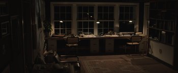 Movie still from “The Night House” (2020), directed by David Bruckner – A room with a desk and chairs in it; Extreme Wide shot, High angle