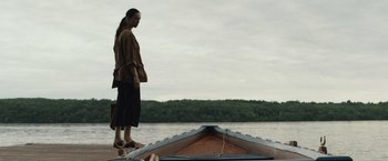 Movie still from “The Night House” (2020), directed by David Bruckner – A woman standing on the side of a boat in the water; Wide shot, Low angle