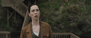Movie still from “The Night House” (2020), directed by David Bruckner – A woman wearing a brown jacket looking to her left; Close Up shot, Low angle