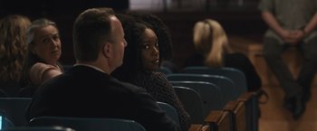 Movie still from “The Night House” (2020), directed by David Bruckner – A woman sitting in front of a man in a theater; Close Up shot, Over the shoulder angle
