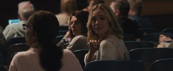 Movie still from “The Night House” (2020), directed by David Bruckner – A group of people sitting in a row of seats; Close Up shot, Over the shoulder angle