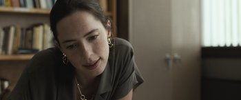 Movie still from “The Night House” (2020), directed by David Bruckner – A person wearing a shirt and earrings; Close Up shot, Over the shoulder angle