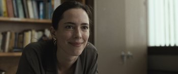 Movie still from “The Night House” (2020), directed by David Bruckner – A person smiling for the camera; Close Up shot, Over the shoulder angle