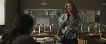 Movie still from “The Night House” (2020), directed by David Bruckner – A woman holding a purse while standing in front of a desk; Medium shot, Over the shoulder angle