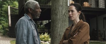 Movie still from “The Night House” (2020), directed by David Bruckner – A man and a woman are standing next to each other; Medium shot, Over the shoulder angle