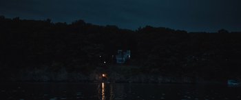 Movie still from “The Night House” (2020), directed by David Bruckner – A house is lit up at night on the water; Extreme Wide shot, Low angle