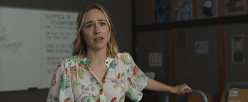 Movie still from “The Night House” (2020), directed by David Bruckner – A woman in a floral shirt is standing in front of a wall; Close Up shot, Over the shoulder angle