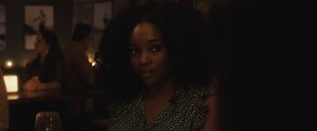 Movie still from “The Night House” (2020), directed by David Bruckner – A young woman with long black hair is smiling for the camera; Close Up shot, Over the shoulder angle