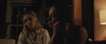Movie still from “The Night House” (2020), directed by David Bruckner – Two women are sitting in the dark and one of them is on her cell phone; Close Up shot, Over the shoulder angle