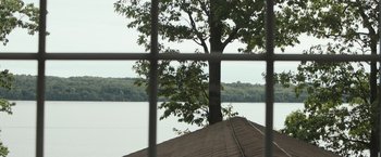 Movie still from “The Night House” (2020), directed by David Bruckner – A view of a lake through a window; Extreme Wide shot, High angle