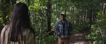 Movie still from “The Night House” (2020), directed by David Bruckner – A man standing in the middle of a forest; Medium shot, Over the shoulder angle
