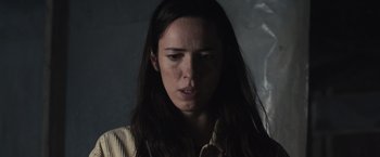 Movie still from “The Night House” (2020), directed by David Bruckner – A woman with long dark brown hair is looking at the camera; Close Up shot, Low angle