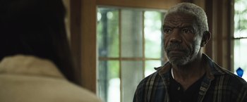 Movie still from “The Night House” (2020), directed by David Bruckner – An older man in a plaid shirt looking at the camera; Close Up shot, Over the shoulder angle