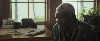 Movie still from “The Night House” (2020), directed by David Bruckner – An older man sitting at a table in front of a window; Close Up shot, Over the shoulder angle