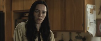 Movie still from “The Night House” (2020), directed by David Bruckner – A woman with long black hair standing in a kitchen; Close Up shot, Low angle
