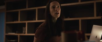 Movie still from “The Night House” (2020), directed by David Bruckner – A woman standing in front of a bookshelf; Close Up shot, Low angle
