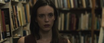 Movie still from “The Night House” (2020), directed by David Bruckner – A woman with long dark brown hair stares into the camera; Close Up shot, Over the shoulder angle