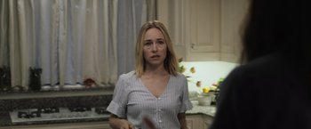 Movie still from “The Night House” (2020), directed by David Bruckner – A woman standing in a kitchen holding a knife; Medium shot, Over the shoulder angle