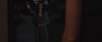 Movie still from “The Night House” (2020), directed by David Bruckner – A woman standing in the dark outside at night; Medium shot, Over the shoulder angle