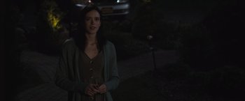 Movie still from “The Night House” (2020), directed by David Bruckner – A woman standing in the dark outside at night; Medium shot, Over the shoulder angle
