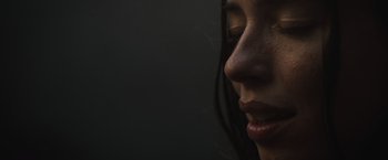 Movie still from “The Night House” (2020), directed by David Bruckner – A woman's face in the dark; Extreme Close Up shot, Low angle