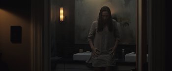 Movie still from “The Night House” (2020), directed by David Bruckner – A woman standing in front of a bathroom mirror; Medium shot, Overhead angle