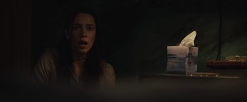 Movie still from “The Night House” (2020), directed by David Bruckner – A woman in a dimly - lit room looking at a monitor; Close Up shot, High angle