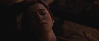 Movie still from “The Night House” (2020), directed by David Bruckner – A woman with her eyes closed and her hand touching her head; Close Up shot, High angle