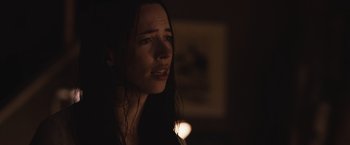 Movie still from “The Night House” (2020), directed by David Bruckner – A person with long dark hair; Close Up shot, Over the shoulder angle
