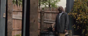Movie still from “The Night House” (2020), directed by David Bruckner – An older man standing in front of a trash can; Medium shot, Low angle