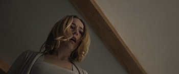 Movie still from “The Night House” (2020), directed by David Bruckner – A woman with long blonde hair blowing in the wind; Close Up shot, Low angle
