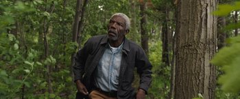 Movie still from “The Night House” (2020), directed by David Bruckner – An older man standing in the middle of a forest; Medium shot, Low angle